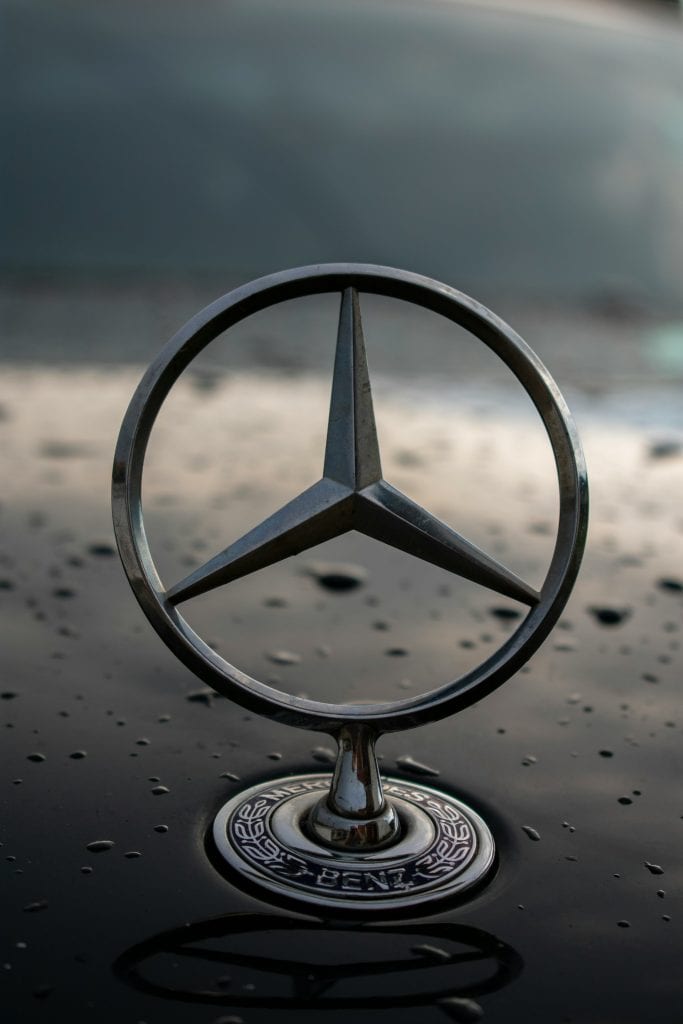 Gros plan sur un emblème Mercedes-Benz, brillant sur un fond épuré—symbolisant le prestige et la valeur cachée des limousines berlines pour le Grand Prix de Montréal 2025.