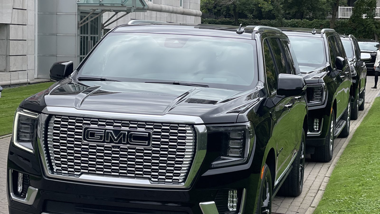 Three black GMC Denali SUVs lined up outside a Montreal venue