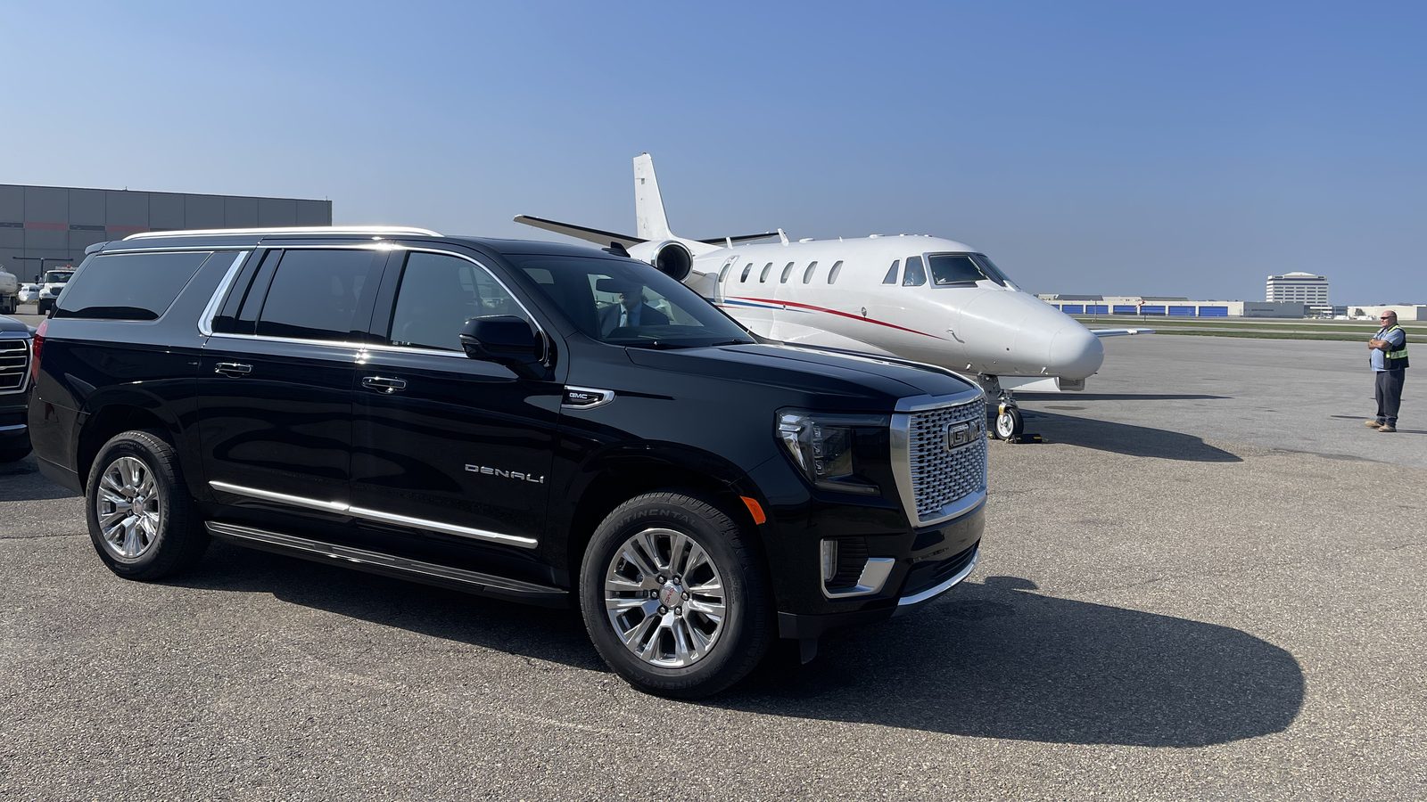 VUS GMC Yukon XL Denali noir attendant près d'un jet privé à l'aéroport de Montréal