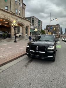 A Lincoln Navigator limousine parked in front of a luxury hotel in Ottawa, angled, south-west view of the Montreal limousine with the entrance visible sideways.